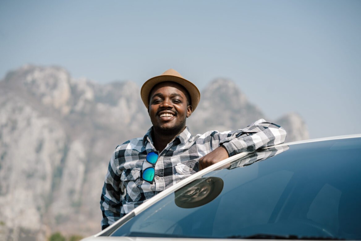 African traveler man standing with car on to the mountains